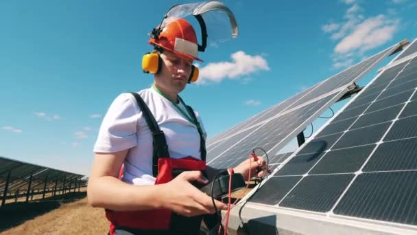 Engenheiro está verificando a tensão em baterias solares — Vídeo de Stock