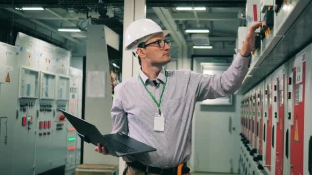 Mannlig tekniker sjekker spenning i maskinrommet. – stockvideo