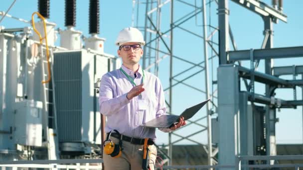 Ingeniero masculino está inspeccionando una central eléctrica al aire libre — Vídeos de Stock