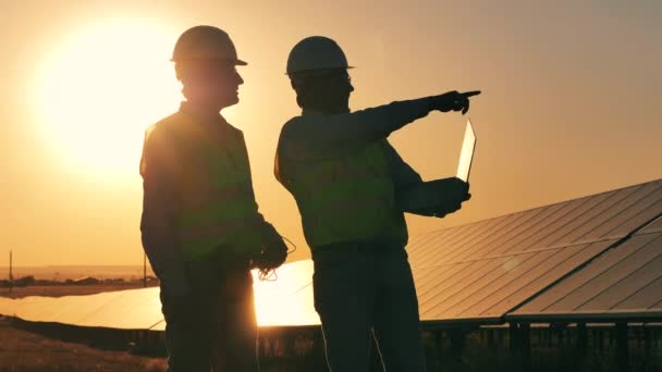 Energía renovable, planta solar, concepto de electricidad verde. Técnicos solares masculinos están hablando a la luz del sol — Vídeos de Stock