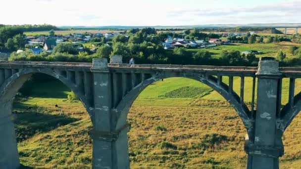 Puente desolado con un turista deportivo cruzándolo — Vídeo de stock