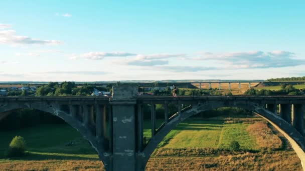 Male athlete is running along an abandoned bridge in the distance — Stock Video