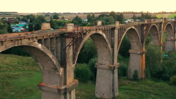 Una dama está corriendo a lo largo de un puente abandonado en la distancia — Vídeos de Stock