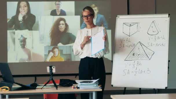 Женщина говорит о геометрических фигурах во время онлайн-урока — стоковое видео