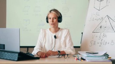 Çevrimiçi öğrenme, çevrimiçi eğitim, çevrimiçi eğitim, uzaktan çalışma, uzaktan eğitim, uzaktan eğitim kavramı. Kulaklık ve mikrofonlu bir öğretmen online bir ders yapıyor.