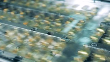 Kapsül paketleri bir hat üzerinde hareket ediyor. Eczane endüstrisi, tıbbi fabrika üretim hattı.