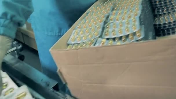 一位工人把装有药丸的水泡放进一个盒子里. — 图库视频影像