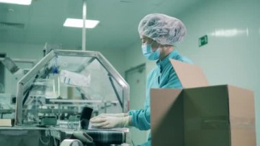 Asyalı etnik köken laboratuvar çalışanı tüpleri kutulara dolduruyor.