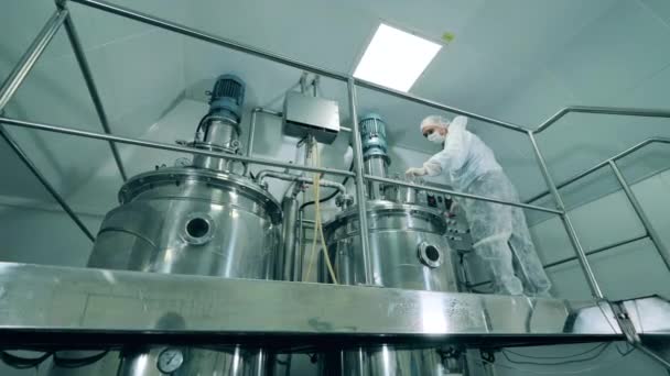 Trabajador de laboratorio mezcla líquido en una máquina. — Vídeos de Stock