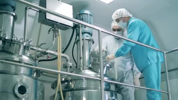Las personas trabajan en laboratorio, mezclando medicamentos en una máquina. — Vídeos de Stock