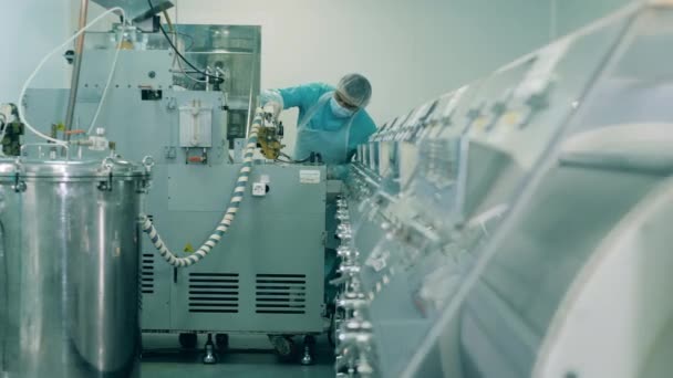 Bir işçi tıbbi laboratuvarda makineyi kontrol ediyor.. — Stok video