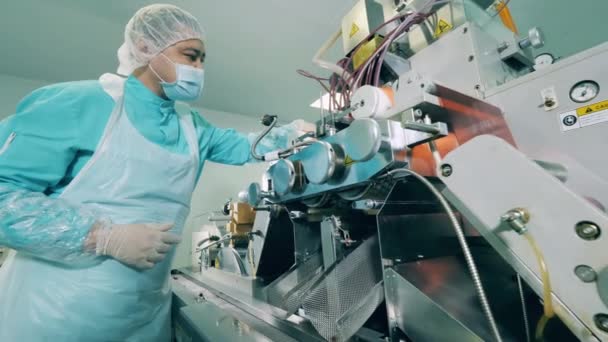 O homem trabalha com uma máquina de transporte em laboratório. Linha de produção farmacêutica em uma instalação moderna. — Vídeo de Stock