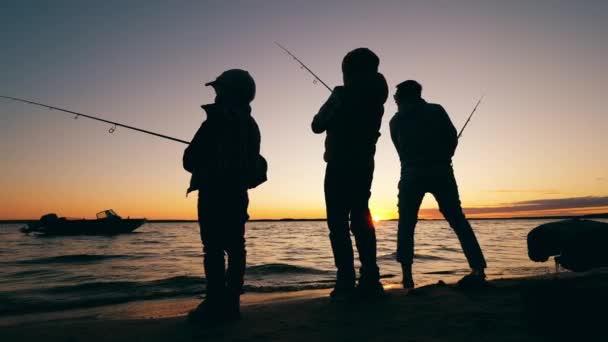 Τα παιδιά ψαρεύουν με έναν ενήλικα από την ακτή. — Αρχείο Βίντεο