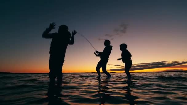 Çocuklar balık tutarken babalarını destekliyorlar. — Stok video