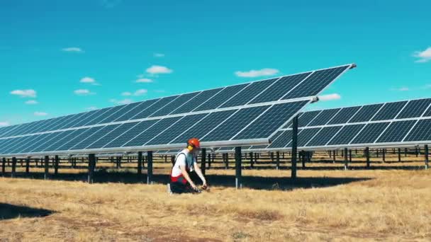 Trabajador está reparando baterías en la planta eléctrica solar — Vídeos de Stock