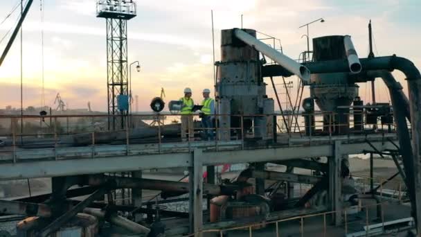 Engenheiros de mineração estão falando enquanto estão de pé em uma construção portuária — Vídeo de Stock