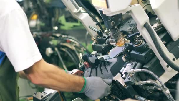 En arbetare sätter en sko i en maskin som formar den. Fabrikstillverkning av skodon. — Stockvideo