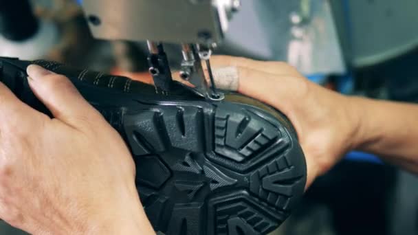 Fabrieksarbeider naait mechanisch een laars. Productiefaciliteiten voor schoeisel. — Stockvideo