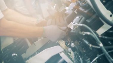 Ayakkabı fabrikası işçisi mekanik olarak bir çizme yapıyor.