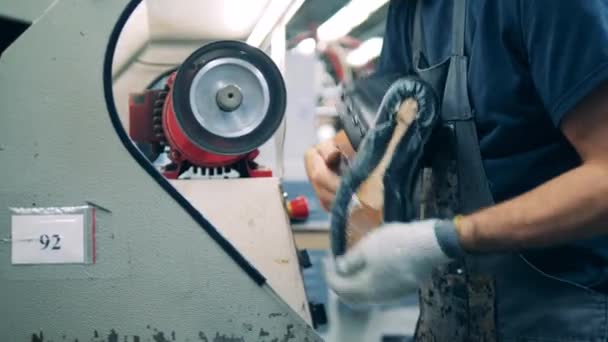 Ο εργάτης γυαλίζει μια μπότα με μια μηχανή. — Αρχείο Βίντεο