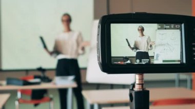 Bayan öğretmen bir internet dersi veriyor ve filme alınıyor. Uzaktan eğitim, çevrimiçi eğitim, uzaktan eğitim, çevrimiçi öğrenme kavramı.