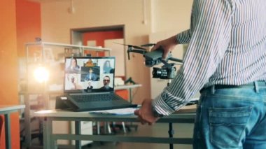 Erkek öğretmen çoklu kullanıcı çevrimiçi sınıfında bir drone gösteriyor