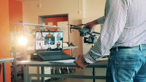 Man tutor toont een drone tijdens een multiuser online klasse — Stockvideo