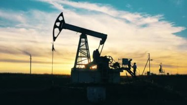 Petrol pompalama inşaatı ve gün batımında iki teknisyen