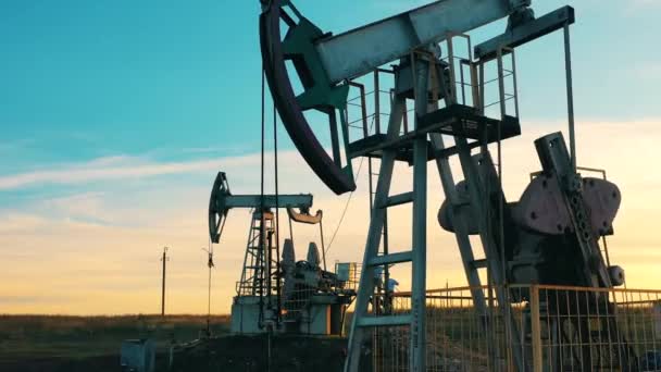 Metalowe jednostki pompują ropę na placu budowy. Studnia naftowa, ropa naftowa, platforma wiertnicza, pole naftowe, cena ropy naftowej, ropa i gaz, beczka naftowa, koncepcja przemysłu naftowego. — Wideo stockowe