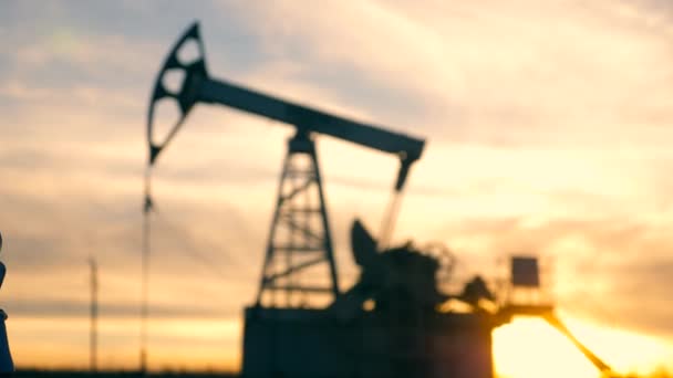 Male handshake with an oil pumping unit in the background. Oil well, crude oil, drilling rig, oil field, crude oil price, oil and gas, oil barrel, oil industry concept. — Stock Video