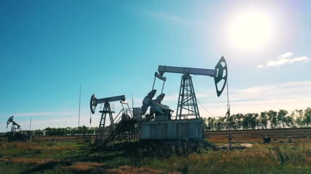 Sito di sviluppo dell'olio con unità di pompaggio funzionanti. Pozzo petrolifero, petrolio greggio, impianto di perforazione, giacimento petrolifero, prezzo del petrolio greggio, petrolio e gas, barile di petrolio, concetto di industria petrolifera. — Video Stock
