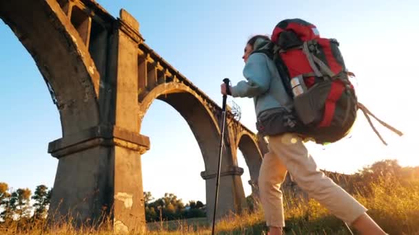 Female tourist is walking and looking around a deserted bridge — Stock Video