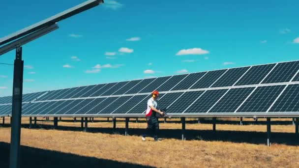 Homem de manutenção está observando linhas de baterias solares — Vídeo de Stock