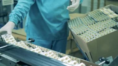 Tıp çalışanı tabletleri bir kutunun içine koyuyor.