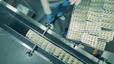 Sağlık çalışanı kapsül kabarcıklarını bir kutuya koyuyor.