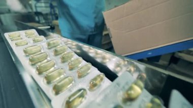 Eczacı, kapsül kabarcıklarını bir kutuya dolduruyor. Eczacı, ilaç endüstrisi konsepti..