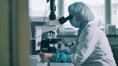 Mikroskop kullanan kadın bir tıp uzmanı.