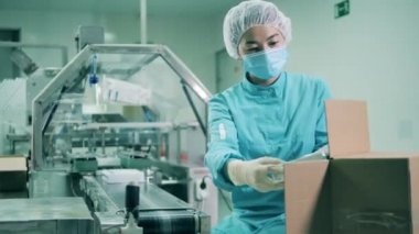 İlaç paketleyen kadın sağlık çalışanı. Uyuşturucu üretimi, eczacı işi, ilaç üretimi, ilaç endüstrisi konsepti.