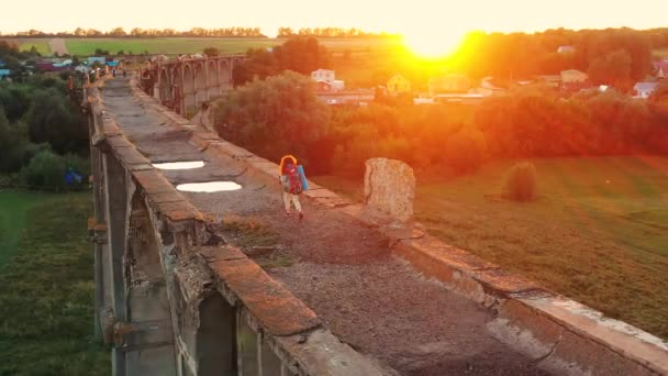 A lady is crossing a massive stone bridge with sports inventory — Stock Video