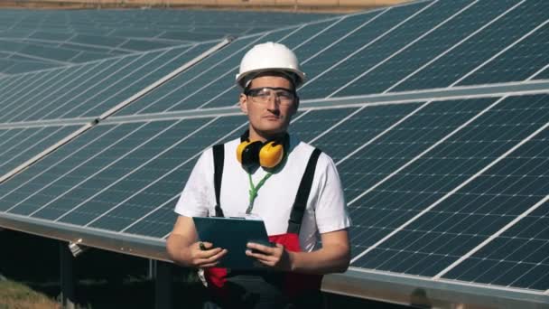 El ingeniero de energía solar sonríe a la cámara. Eficiencia energética, concepto de ahorro energético. — Vídeo de stock