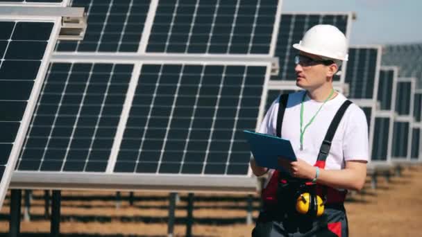 Opravář si dělá poznámky o solárních panelech — Stock video