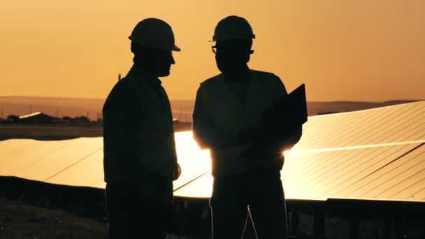 Erkek uzmanlar güneş enerjisini gün batımında tartışacaklar. — Stok video