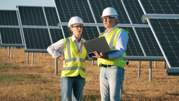 Twee energiedeskundigen hebben het over zonnebatterijen. — Stockvideo