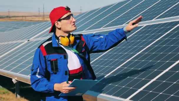 El encargado del servicio está revisando baterías solares al aire libre. Eficiencia energética, concepto de ahorro energético. — Vídeos de Stock