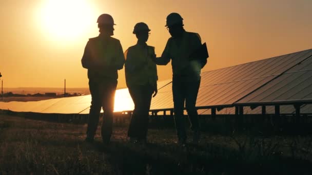 Gli specialisti di energia stanno parlando accanto alle batterie solari al tramonto. Efficienza energetica, concetto di risparmio energetico. — Video Stock