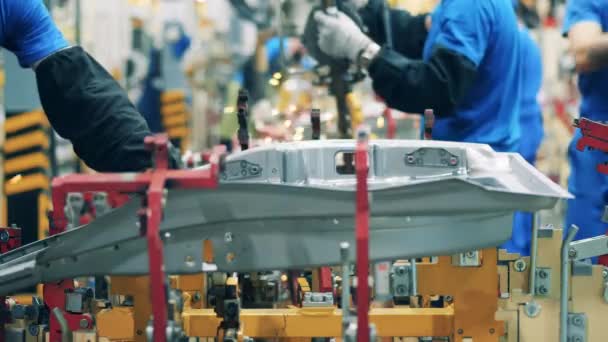 Mechaniker bewegen ein Fertigteil in eine Autofabrik. Moderne Produktion von Autos. Nahaufnahme — Stockvideo