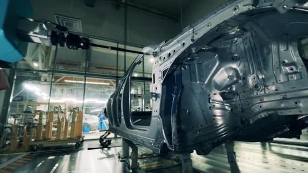 Roboter einer Autofabrik inspiziert eine Karosserie — Stockvideo