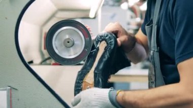 Deri bot bir fabrika işçisi tarafından cilalanıyor.