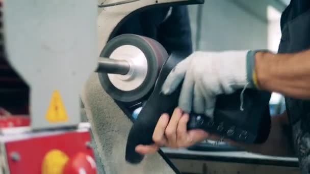 Fabrikarbeiter poliert mit einer Maschine einen Lederstiefel — Stockvideo