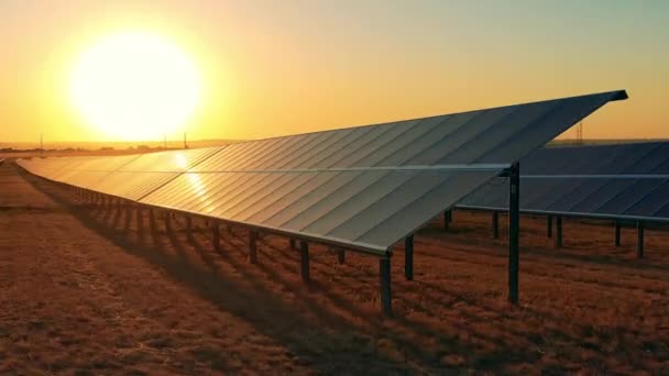 Filas de paneles fotovoltaicos en el campo al atardecer — Vídeos de Stock